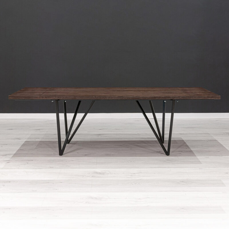 Stół Ravel z dostawkami wykonany z litego drewna dębowego pokrytego bejcą i metalu.