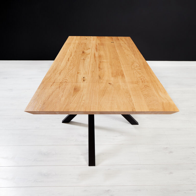 Stół z dostawkami Slant wykonany z litego drewna dębowego i metalu.