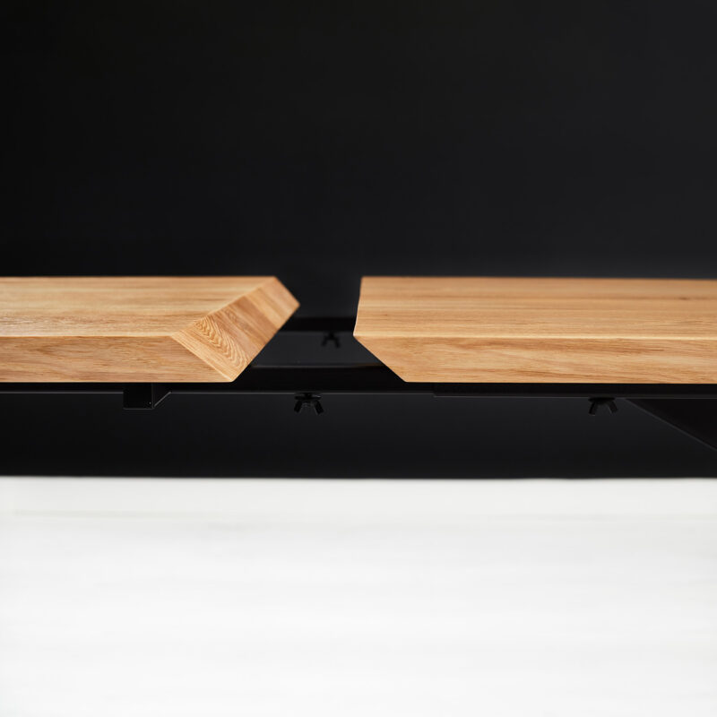Stół z dostawkami Slant wykonany z litego drewna dębowego i metalu.